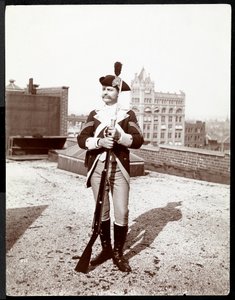 Mies katolla perinteiseen sotilasasuun pukeutuneena, kädessään kivääri, 1895 (hopeagelatiinipaino).